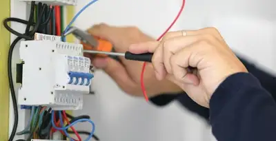 Electrician installing and adjusting circuit breakers in an electrical panel in Atlanta, GA