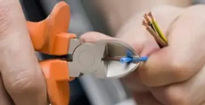 licensed electrician performing precise wire cutting and preparation during electrical service in Atlanta, GA