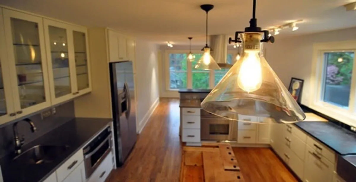 Residential electrician installing modern indoor light fixture in a home in Atlanta, GA