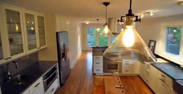 Residential electrician installing modern indoor light fixture in a home in Atlanta, GA