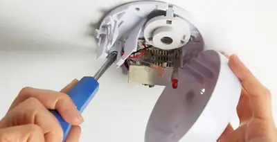 Certified technician wiring smoke detector during installation in Atlanta, GA